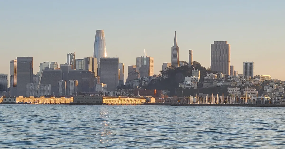 The San Francisco skyline with Salesforce Tower, the Transamerica Pyramid and Coit Tower above the waterfront, seen from a boat on the bay